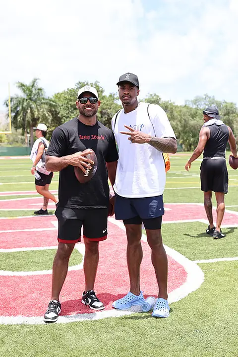 Craig LeBlanc with pro football players at an outdoor training camp